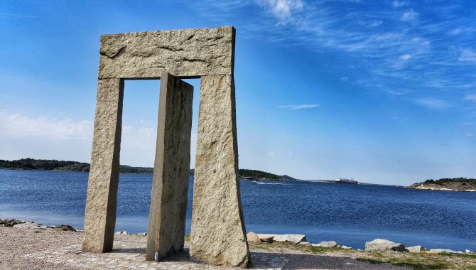 Granitskulptur Porten mot Västerhavet, 4 meter hög som liknar en port med en vinklad granitsten i mitten.