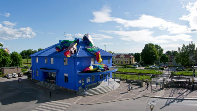 En bild på ett väldigt blått stationshus dekorerat med konst i olika färger.