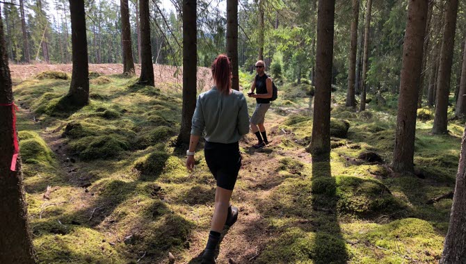 Folk på rad i skogen på Lassalyckans 7 km långa trailbana.