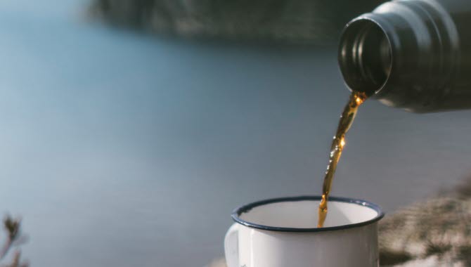 Kaffe i mugg från termos med utsikt
