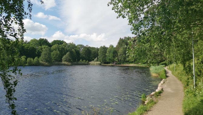 sjö med en gångstig i grus bredvid.