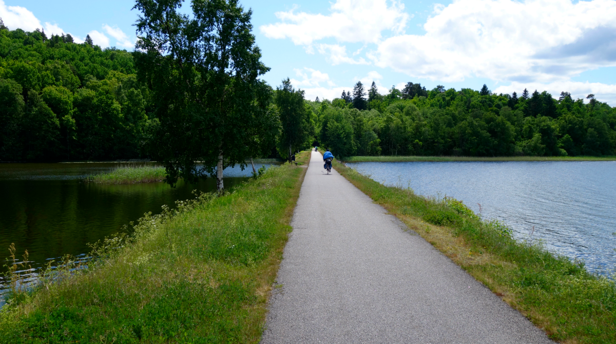 A paved cycle path with water on both sides