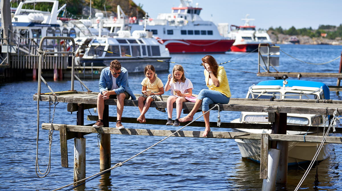 Familj sitter på brygga i centrala Strömstad