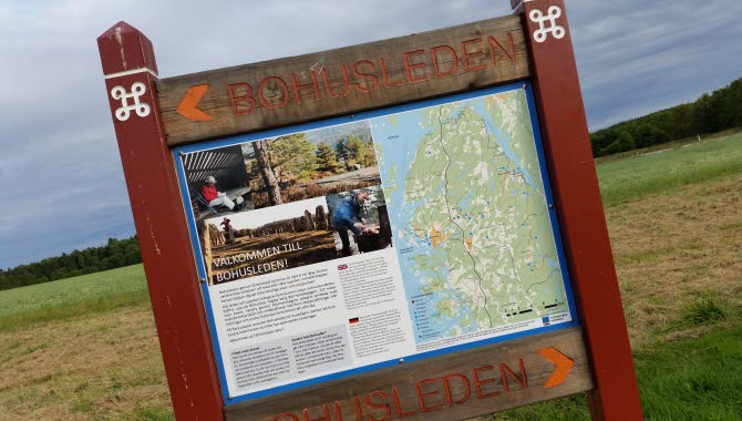 Informationsskylt Bohusleden med bilder och karta över leden i Strömstad kommun