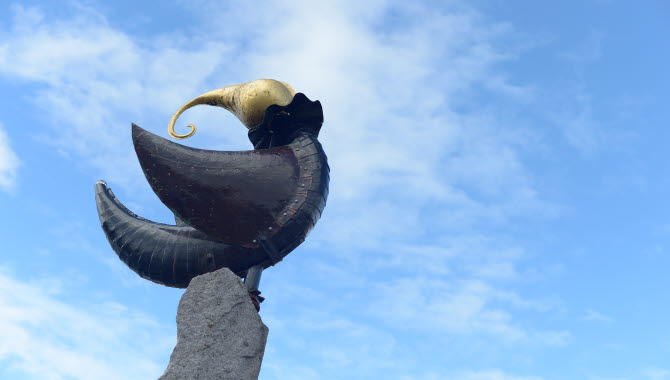 Kvinda, bronsstay vid norra hamnen föreställande ett havskryp