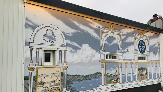 Väggmålning på en brandvägg som visra kyrkans historia