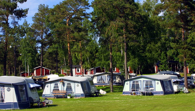 Campingstugor och husvagnar en solig dag i den gröna naturen.