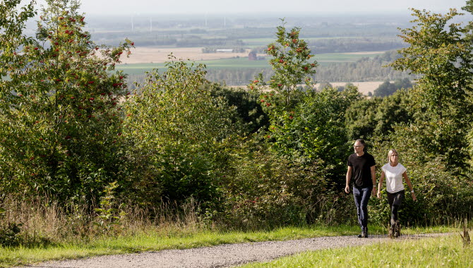 man och kvinna som promenerar med vacker utsikt från berget i bakgrunden.