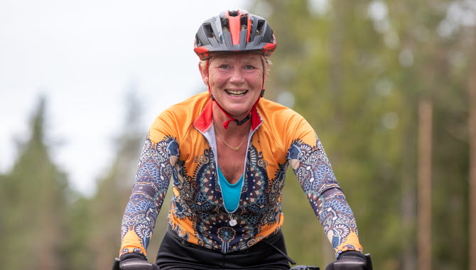 Kvinnlig cyklist med hjälm och färgglada kläder.