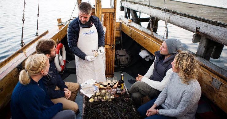 People tasting oysters on a boat