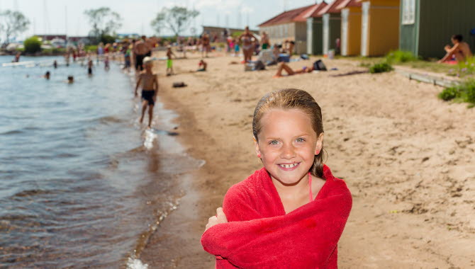 Tjej som precis kommit upp ifrån vattnet på Guldkroksbadet.