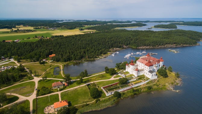 Flygbild på ett vitt slott med rött tak.