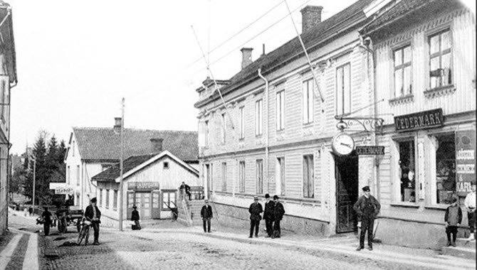 Gammalt fotografi som visar stadslivet i Hjo - Hamngatan.