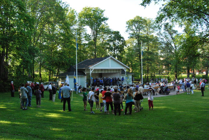 Människor som ser på ett uppträde i Bruksvilleparken i Tidaholm.