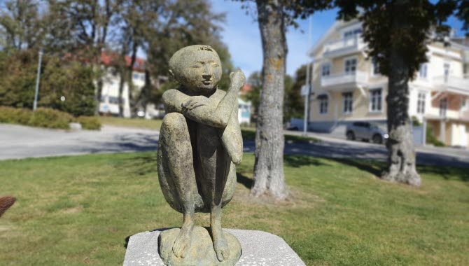 Bronsstay, en pojke som sitter på huk med kramande armar