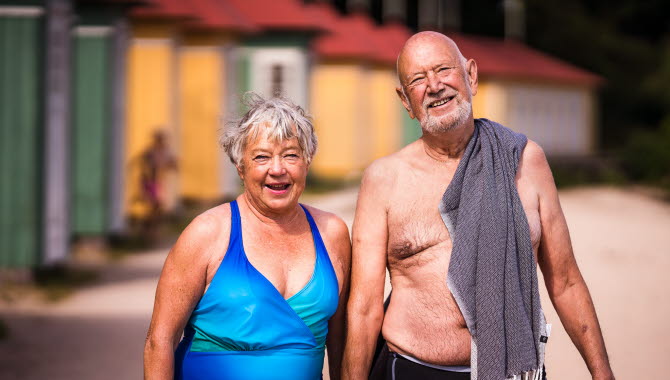 Äldre par vid Guldkroksbadets sandstrand i Hjo.